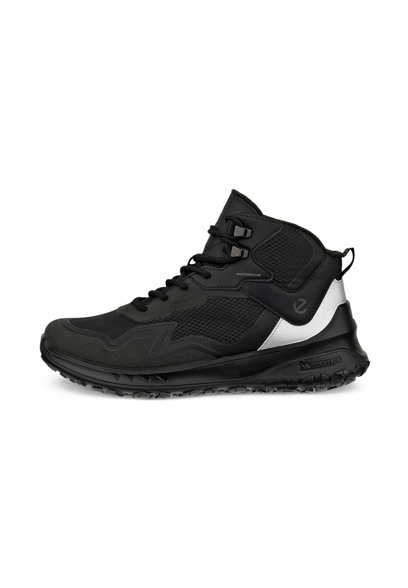 Scarpe da trekking impermeabili nere con tomaia in mesh testurizzato, suola imbottita e un distintivo accento argentato sul lato.