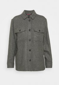 Giacca camicia in lana grigia con maniche lunghe, chiusura con bottoni, due tasche sul petto e colletto classico. Presenta bottoni neri e un tessuto testurizzato.