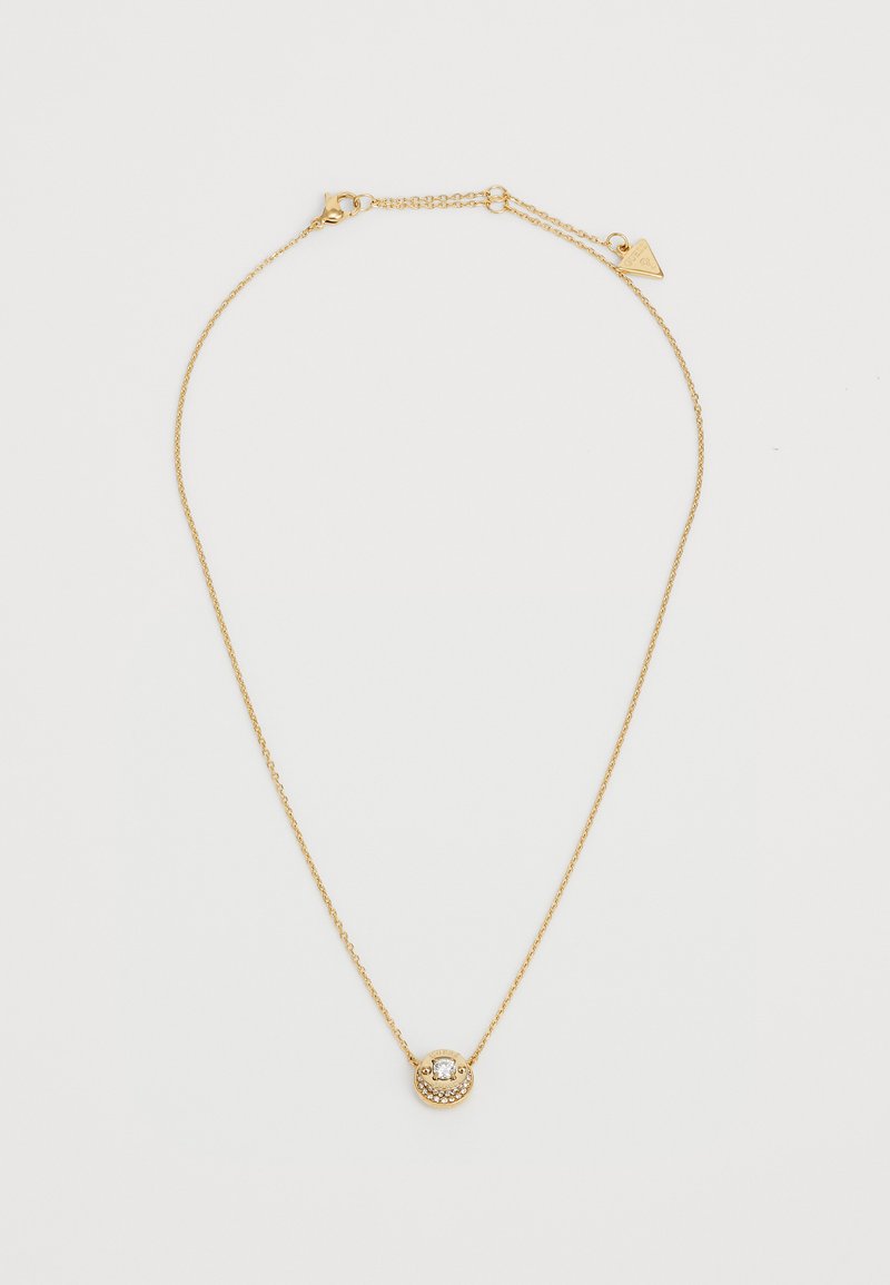 Gullkjede med et vedheng som har et sirkulært design, dekorert med små krystaller og hevede detaljer. Justerbar kjedelengde.