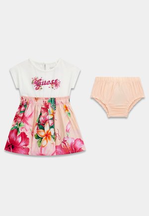 Robe pour tout-petit avec haut blanc portant le logo "Guess" et jupe fleurie, accompagnée d'un bloomer rose clair assorti.