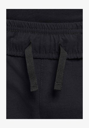 Zwarte katoenen joggers met een elastische tailleband en een trekkoord. Heeft een gladde textuur en gestikte details. Verstelbare banden zijn zichtbaar.