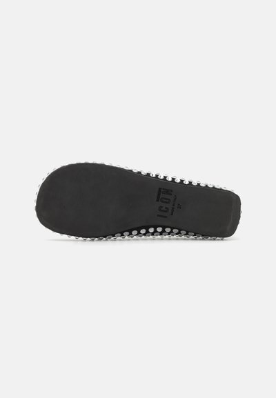 Black rubber shoe sole with small silver studs along the edge. Text identifies the brand and size. Textured surface for grip.