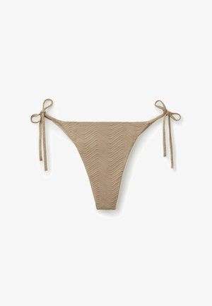 Beżowy dół od bikini z teksturowanej tkaniny z wiązaniami po bokach tworzącymi kokardki na białym tle.