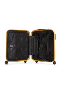 Žlutý tvrdý kufr s otevřeným designem, vybavený černým interiérem, křížovými popruhy, zipovými přihrádkami a dvěma kolečky.