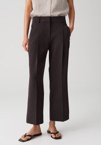 High-waisted black wide-leg trousers made of smooth fabric, featuring sharp creases, side pockets, and a tailored fit.