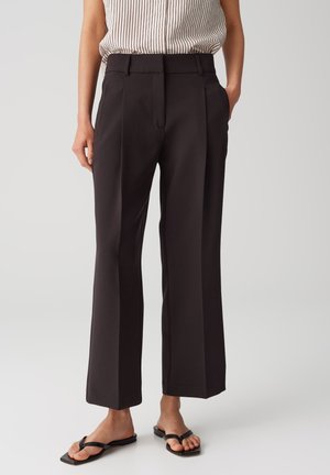 Pantaloni neri a vita alta con gamba larga, realizzati in tessuto liscio, con pieghe nette, tasche laterali e una vestibilità sartoriale.