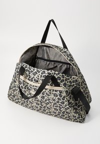 Geantă tip duffle realizată dintr-un material textil cu un model în tonuri de bej deschis și negru, având două mânere negre, un fermoar superior și un interior spațios.