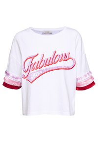 Bílý bavlněný zkrácený tričko s nápisem "Fabulous" v růžové a červené barvě, s pruhovanými červenými a růžovými třásněmi na krátkých rukávech.