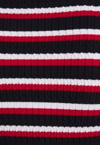 Tissu en tricot côtelé présentant des rayures horizontales en rouge, blanc et noir ; la texture est tactile avec un motif en relief.