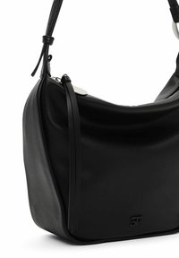 Sac à épaule en cuir noir avec une forme douce et courbée. Il possède une sangle élégante, un accent décoratif et un détail de logo en relief sur le devant.