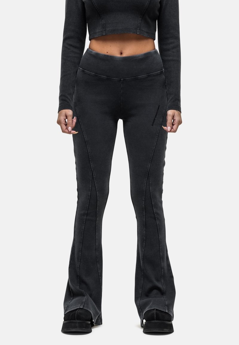 Zwarte flared jeans in een geribbelde textuur, met opvallende zijnaad en hoge taille. Draag ze met een bijpassende cropped top.