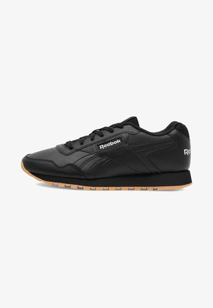Zapatos deportivos negros hechos de cuero sintético con superficie texturizada, suela de goma, diseño de cordones y logo de Reebok.