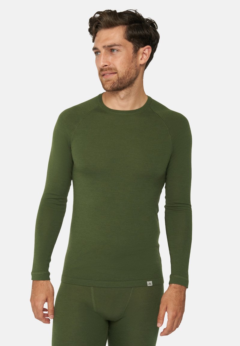 Langærmet baselayer-top i mørkegrønne stof, med rund halsudskæring, ribbede manchetter og en tætsiddende facon. Diskret logo på kanten.