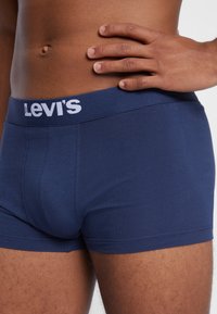 Marineblå bomullsboxershorts med en hvit "Levi's" logo på midjebåndet. Har en tett passform og glatt tekstur.