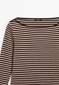 Haut à manches longues rayé en beige et marron foncé. Il présente un large décolleté et est fait d'un coton doux, avec des rayures horizontales uniformément espacées.