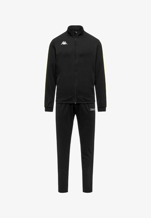 Survêtement noir zippé intégral avec logo blanc sur la poitrine de la veste et nom de la marque blanc sur la cuisse du pantalon, doté de poignets élastiques et de pantalons slim.