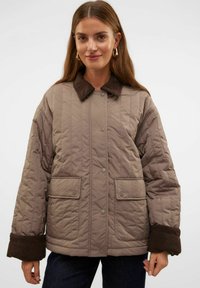 Quiltet, taupe jakke med en fløjlskrave, trykknapper og to frontlommer; har brune mansjetter og et afslappet fit design.