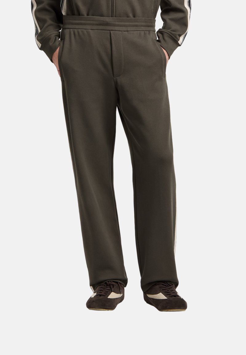 Pantaloni jogger verde oliva realizzati in tessuto morbido, caratterizzati da una vestibilità rilassata, tasche laterali e dettagli con strisce verticali lungo i lati.