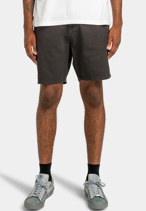 Dunkelgraue Denim-Shorts mit geradem Schnitt, sichtbaren Nähten und sauberem Saum, kombiniert mit hellgrauen Turnschuhen und schwarzen Socken.