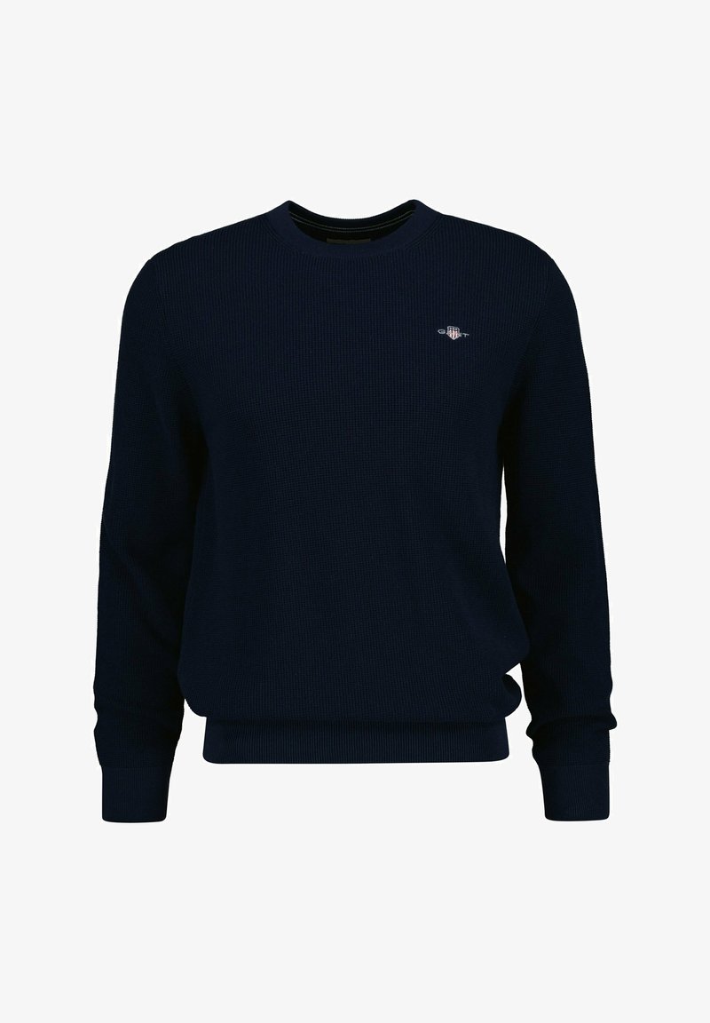 Marineblå tekstureret pullover trøje med lange ærmer, ribstrikkede kanter og et lille logo på brystet. Fremstillet af et behageligt strikket materiale.