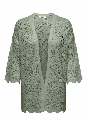 Lys grøn åbenstrikket cardigan med V-hals, korte ærmer og bølgede kanter. Struktureret mønster med store huller hele vejen igennem.