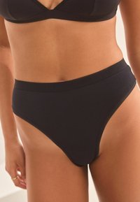 Zwarte hoogsluitende onderbroek gemaakt van gladde stof met een zachte elastische tailleband met een subtiele merkl logo.