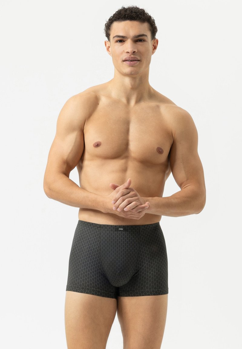 Boxers noirs à motifs fabriqués en tissu doux, présentant une coupe ajustée et une taille élastique arborant le logo de la marque.