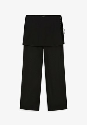 Black wide-leg pants with an attached wrap skirt overlay and button detailing on the right side waistband.