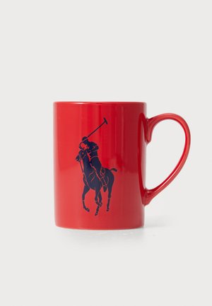 Caneca de cerâmica vermelha com acabamento brilhante, apresentando um gráfico de jogador de polo azul. Alça curva e forma cilíndrica.