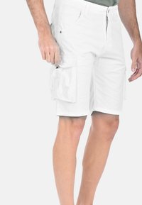 Shorts cargo bianchi realizzati in tessuto leggero, con numerose tasche, zip frontale e taglio dritto. Design piatto e lunghezza al ginocchio.