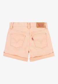 Shorts de mezclilla rosa claro con dobladillos enrollados, bolsillos traseros con el icónico cosido y una etiqueta de cuero marrón en la cintura.