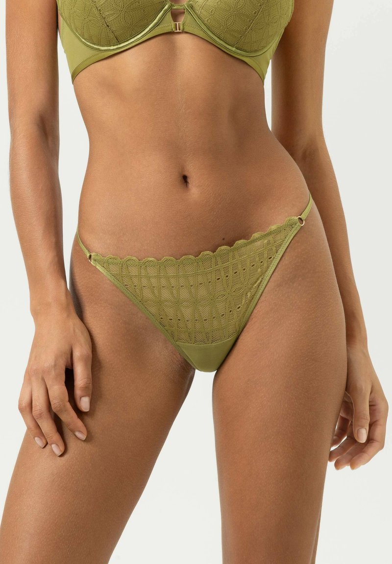 Olivengroene lingerie set met een textuur, kanten patroon beha en getande randen aan het stringonderdeel, voorzien van dunne bandjes en decoratief beslag.