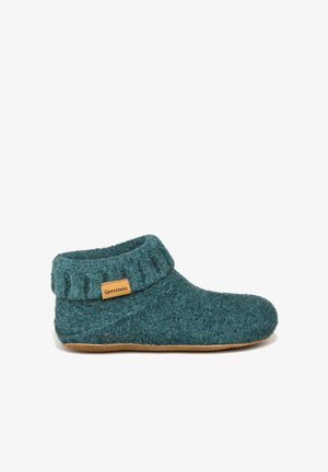 Teal wollen pantoffel met een omgevouwen rand en een tan leren label. Heeft een zachte, gestructureerde buitenkant en een platte rubberen zool.