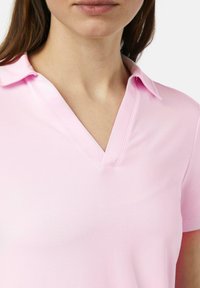 Helles rosa Poloshirt mit V-Ausschnitt und kurzen Ärmeln. Hergestellt aus glattem Stoff, mit einer weichen Textur und subtilen Nähdetails.