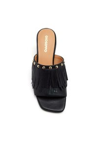 Des sandales noires avec une tige en cuir texturé, présentant des détails à franges, des accents en métal doré et un design à bout carré.