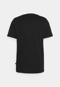 Camiseta negra de manga corta hecha de algodón, con cuello redondo y dobladillo recto. Etiqueta visible en la costura lateral inferior.