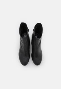 Melnas ādas potītes zābaki ar slaidu siluetu; satur sānu rāvējslēdzēju, gludu tekstūru un noapaļota pirksta dizainu.