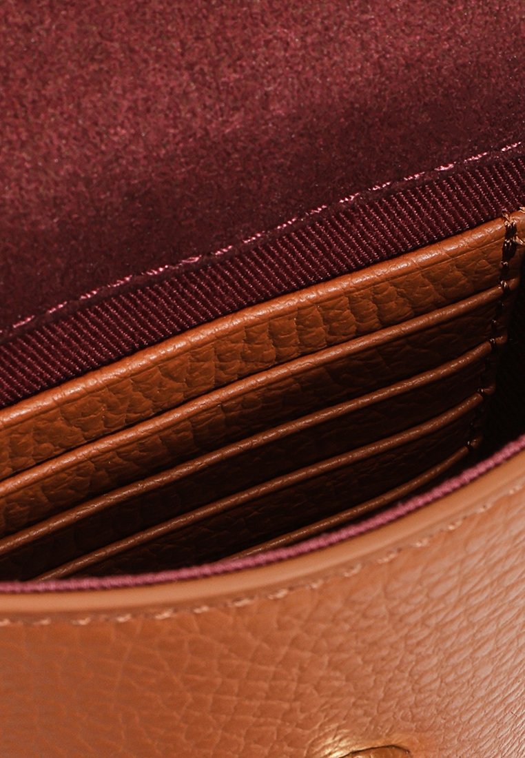 Skórzany portfel w kolorze tan, o gładkiej fakturze, z wieloma miejscami na karty oraz burgundową podszewką. Zaokrąglone brzegi i dyskretne przeszycia.