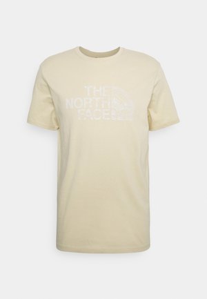 T-shirt beige à manches courtes et col rond avec le logo blanc "The North Face" sur la poitrine et un motif texturé subtil à l'intérieur du logo.