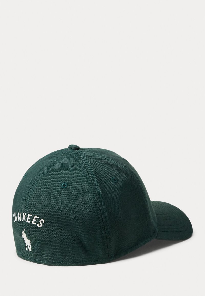 Mörkgrön basebollkeps med broderad "YANKEES" och en liten bild av en älg på baksidan. Slät tyg med en böjd skärm.