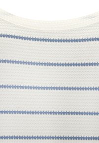 Tejido blanco texturizado con rayas horizontales azul claro, que presenta un diseño sutil. Cuello acanalado con un aspecto suave y tejido.