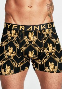 Herrboxershorts i svart bomull med ett guld barockmönster med griffiner, ett brett svart midjeband med "BODYFRANKDA" i guld bokstäver.