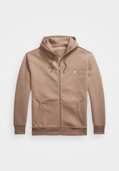 Rjava zip-up kapuca iz mehkega blaga, z sprednjim žepom, vrvico pri kapuci in majhnim vezenim logotipom na prsih.