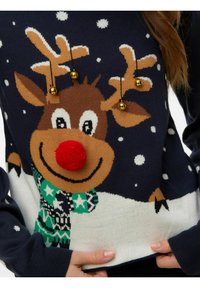 Granatowy sweter z motywem renifera z czerwonym pomponem zamiast nosa, złotymi dzwoneczkami na porożu oraz białymi wzorami śnieżynek. Materiał: mieszanka bawełny.