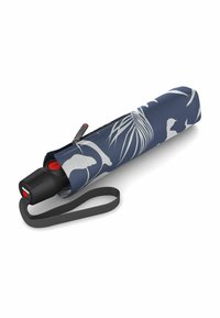  Paraguas compacto con funda de tela azul marino que presenta patrones de hojas blancas. Incluye un mango negro y una correa de muñeca gris con un botón rojo.