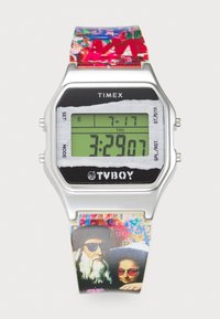 Montre numérique avec un boîtier en métal argenté et un affichage LCD noir. Le bracelet coloré présente des motifs artistiques et des illustrations de deux personnages portant des lunettes de soleil.