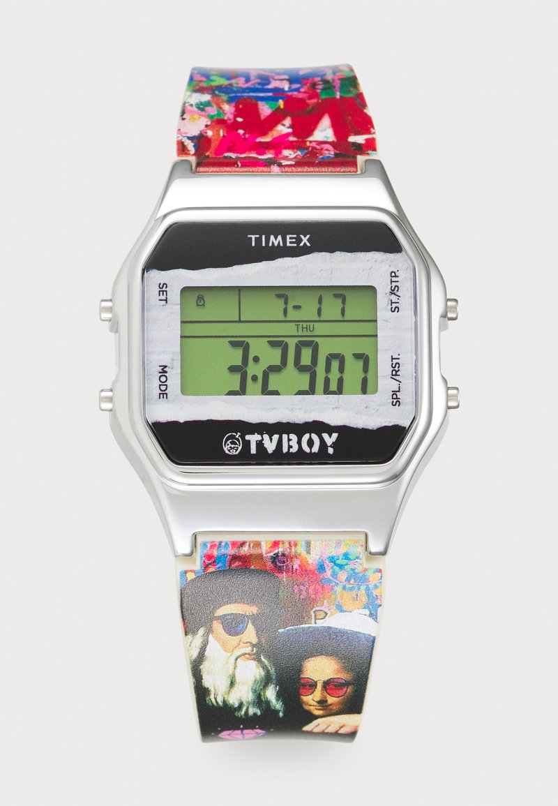 Reloj digital con caja metálica plateada y pantalla LCD negra. La correa colorida presenta patrones artísticos e ilustraciones de dos figuras con gafas de sol.