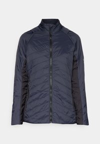 Marinblå isolerad jacka med dragkedja framtill, med diagonala quiltade mönster och kontrasterande svarta sidopaneler. Hög krage och långa ärmar.