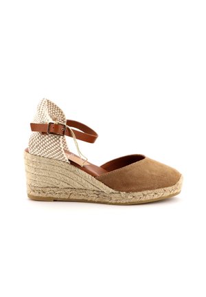 Sandalo a zeppa in suede marrone con retro in tessuto intrecciato, cinturino alla caviglia regolabile e soletta in iuta testurizzata. Design a profilo basso e con punta aperta.
