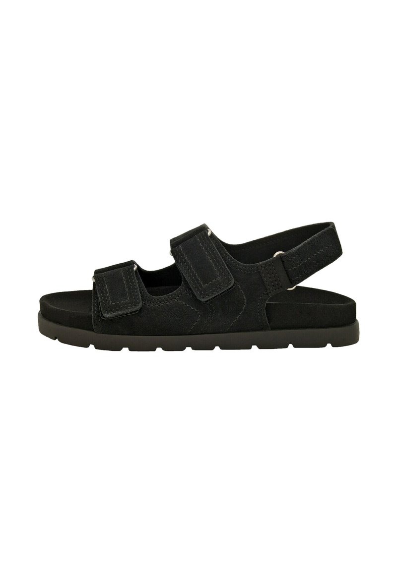 Sandalo in suede nero con due cinturini regolabili in Velcro, una fascia posteriore sul tallone e una suola in gomma testurizzata per una maggiore aderenza.